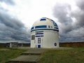 Es ist die Volkssternwarte des Naturwissenschaftlichen Vereins zu Zweibrücken. Als das Observatorium im September 2018 einen neuen Anstrich benötigte, kümmerte sich Hubert Zitt, Informatik-Professor der Fachhochschule in Zweibrücken, darum, dass das Gebäude nun wie der kleine Droide R2-D2 aus dem Star Wars-Universum aussieht. Der 55-jährige Wissenschaftler ist ein großer Fan von Star Trek und Star Wars. Kurzerhand griff Zitt gemeinsam mit Studierenden und einem Malermeister zum Pinsel und verpasste dem Gebäude die typischen Farben des blechernen Wegbegleiters von Luke Skywalker und Co. Insgesamt 120 Arbeitsstunden brauchten Hubert Zitt und sein Team, um die Sternwarte in den R2-D2-Look zu bringen.